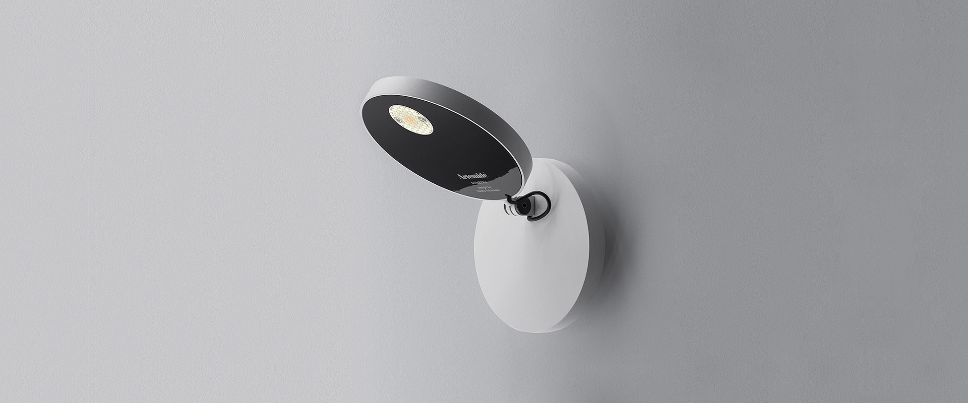 Artemide Demetra Faretto wall spotlight: oval dark head with LED, adjustable arm, mounted on white oval wall base