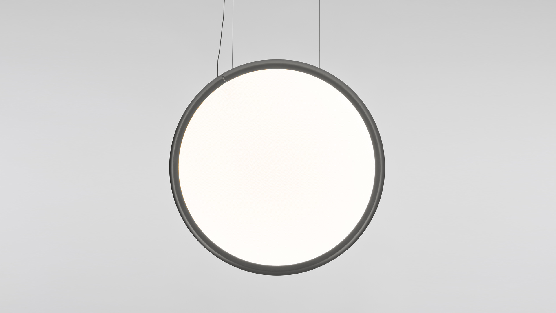 Multiple Artemide Discovery pendant lamps with circular white diffusers and black frames arranged in an overlapping cluster on a dark wall
