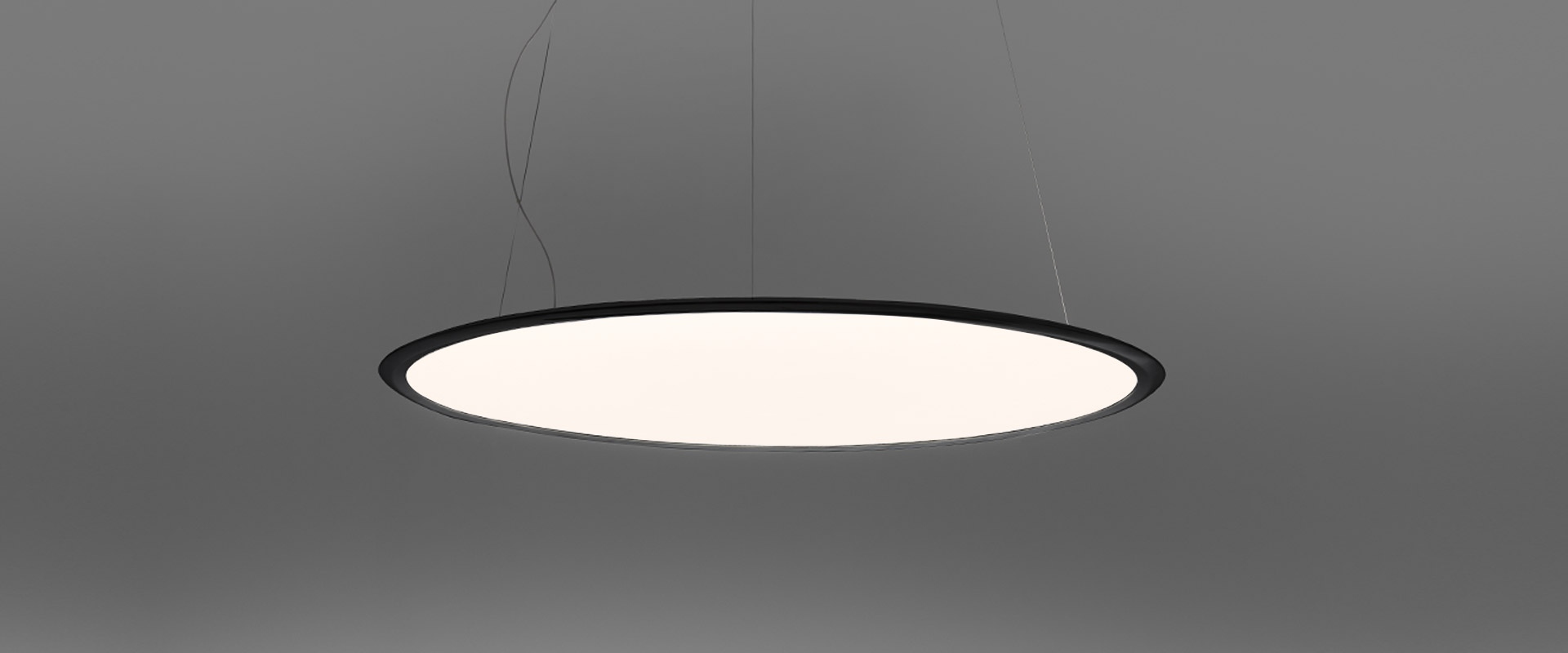 Artemide Discovery pendant lamp: large circular disc with white diffuser and bronze rim, suspended by thin cables