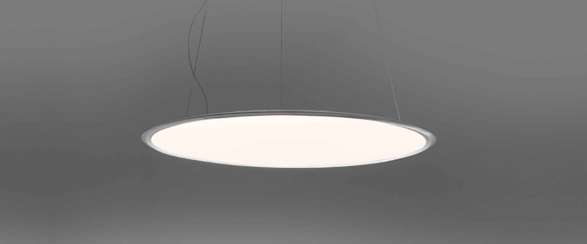 Artemide Discovery pendant lamp: large circular flat disc with white diffuser and slim aluminum rim, suspended by thin cables