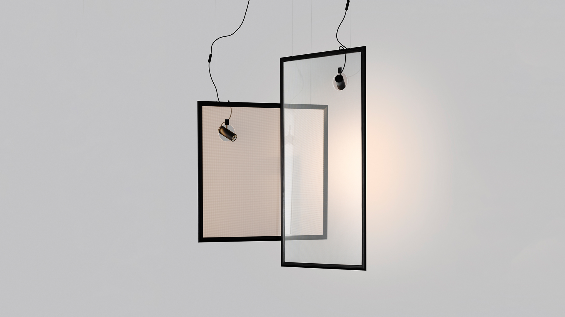 Two overlapping Discovery rectangular pendant frames in black, each with a small Discovery Spot projector, one emitting warm diffused light
