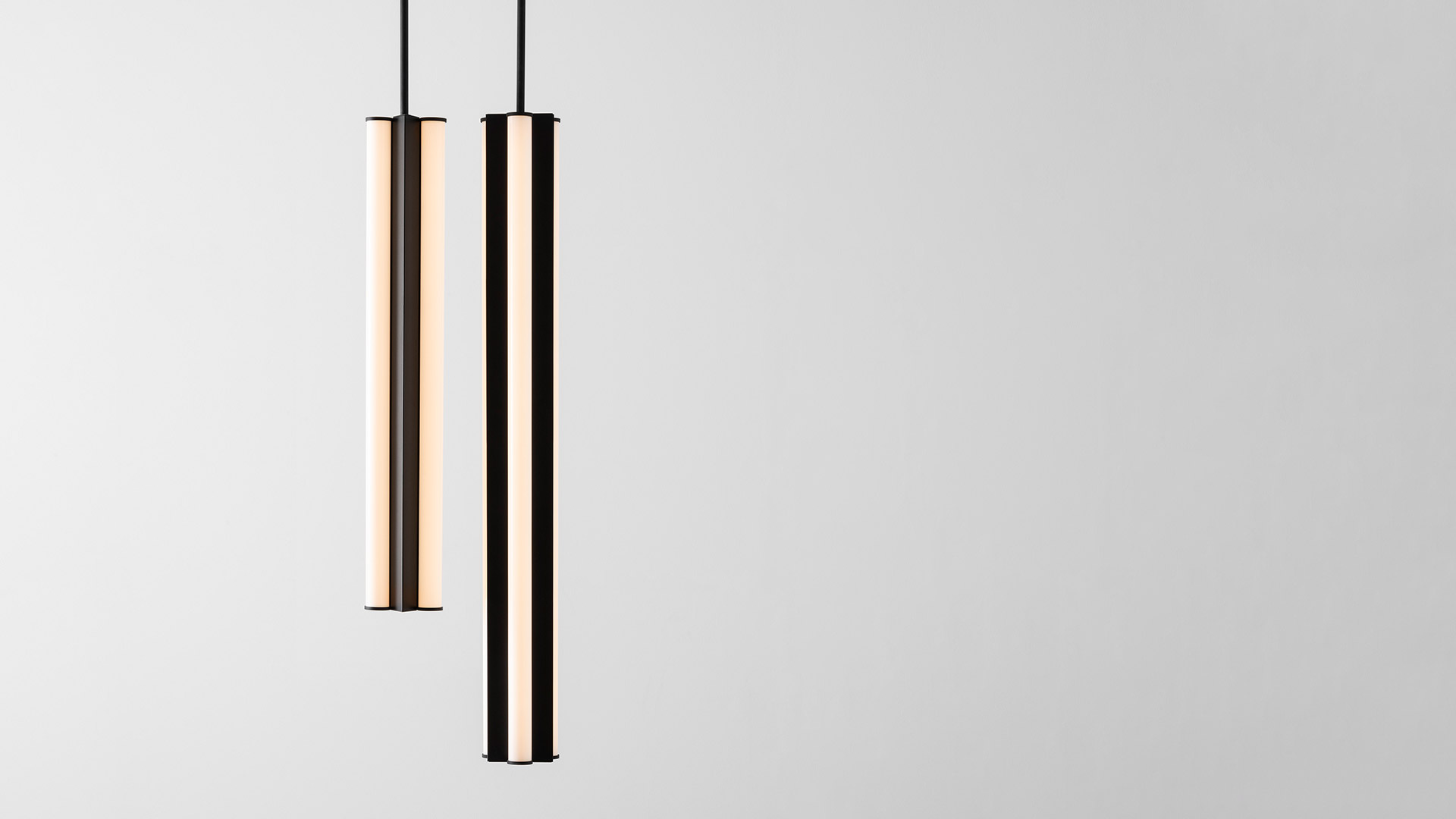 Artemide Dreispitz Outdoor pendant lamp illuminates a minimalist outdoor dining area with table and bench at dusk