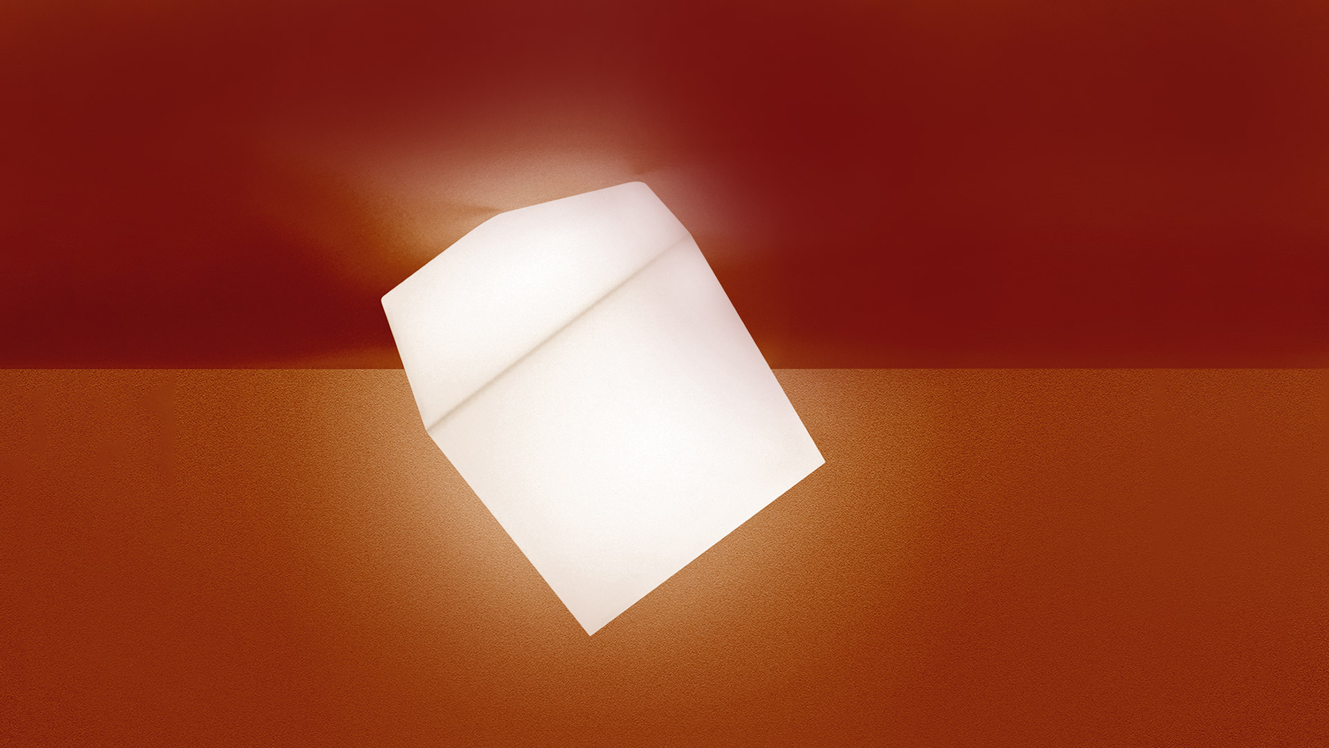 Artemide Edge lamp: tilted white opal cube emitting warm diffused light against a deep red wall and floor