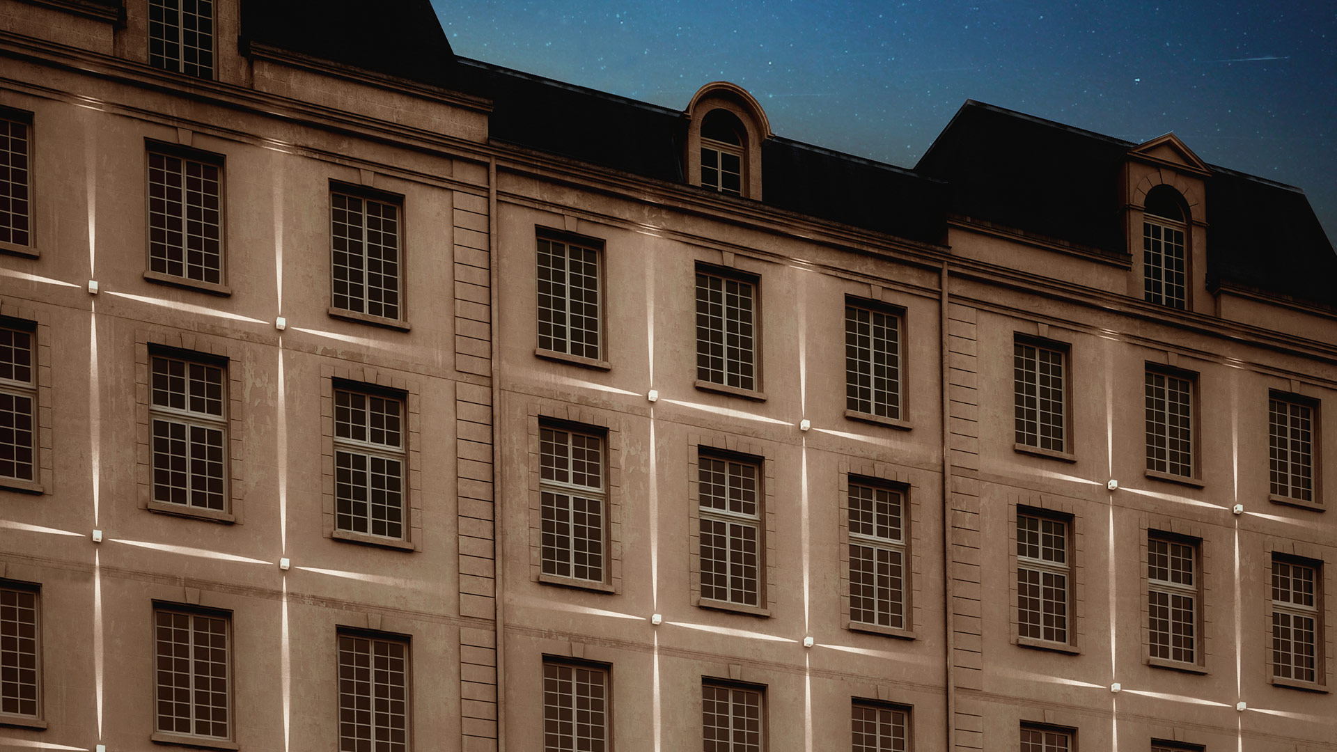 Classic European building facade illuminated at night with vertical linear LED strips creating a warm grid pattern across stone walls.