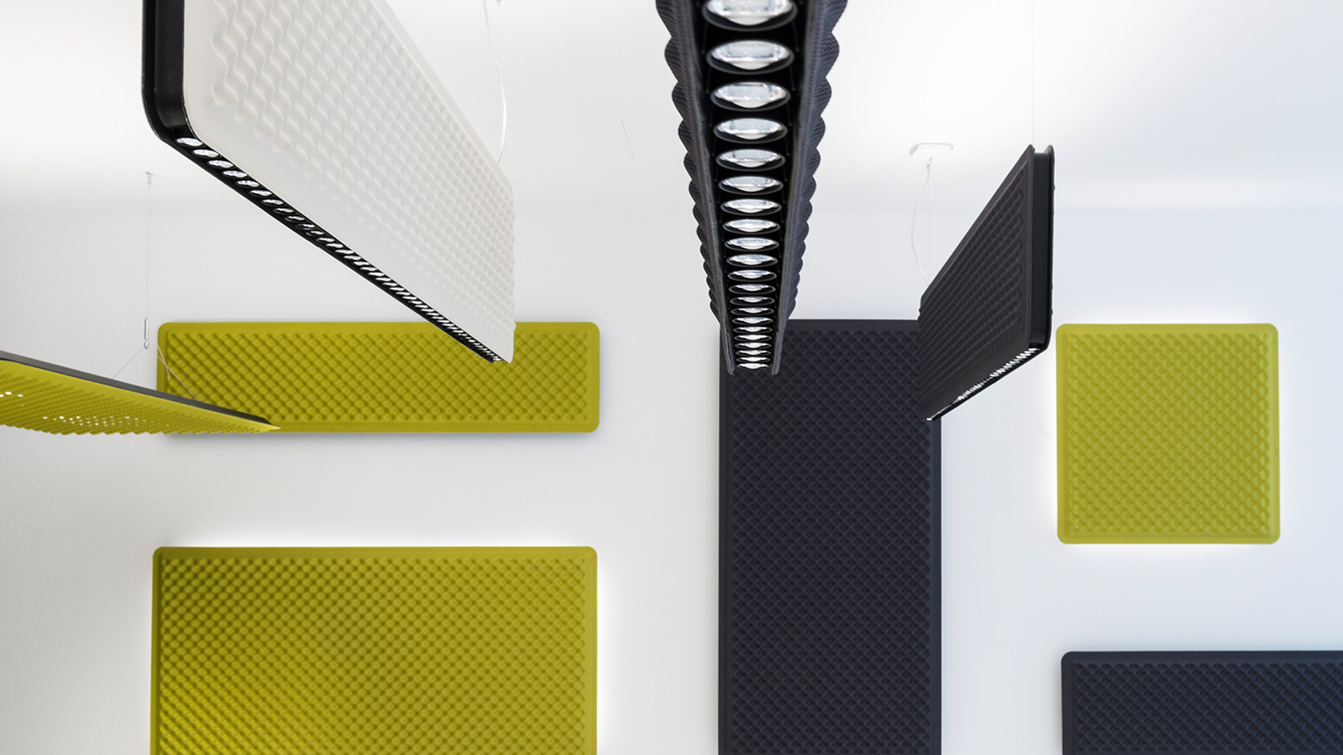 Artemide Eggboard acoustic panels in black, white, and yellow, displayed as ceiling and wall-mounted solutions in a Progetto CMR showroom.