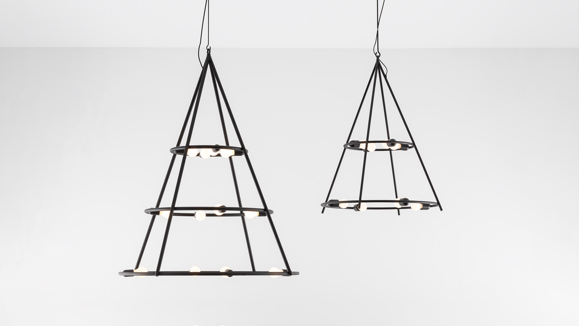 Two Artemide El Porís pendant lights: dark metal conical frames with multiple circular rings holding small globe bulbs, in two sizes