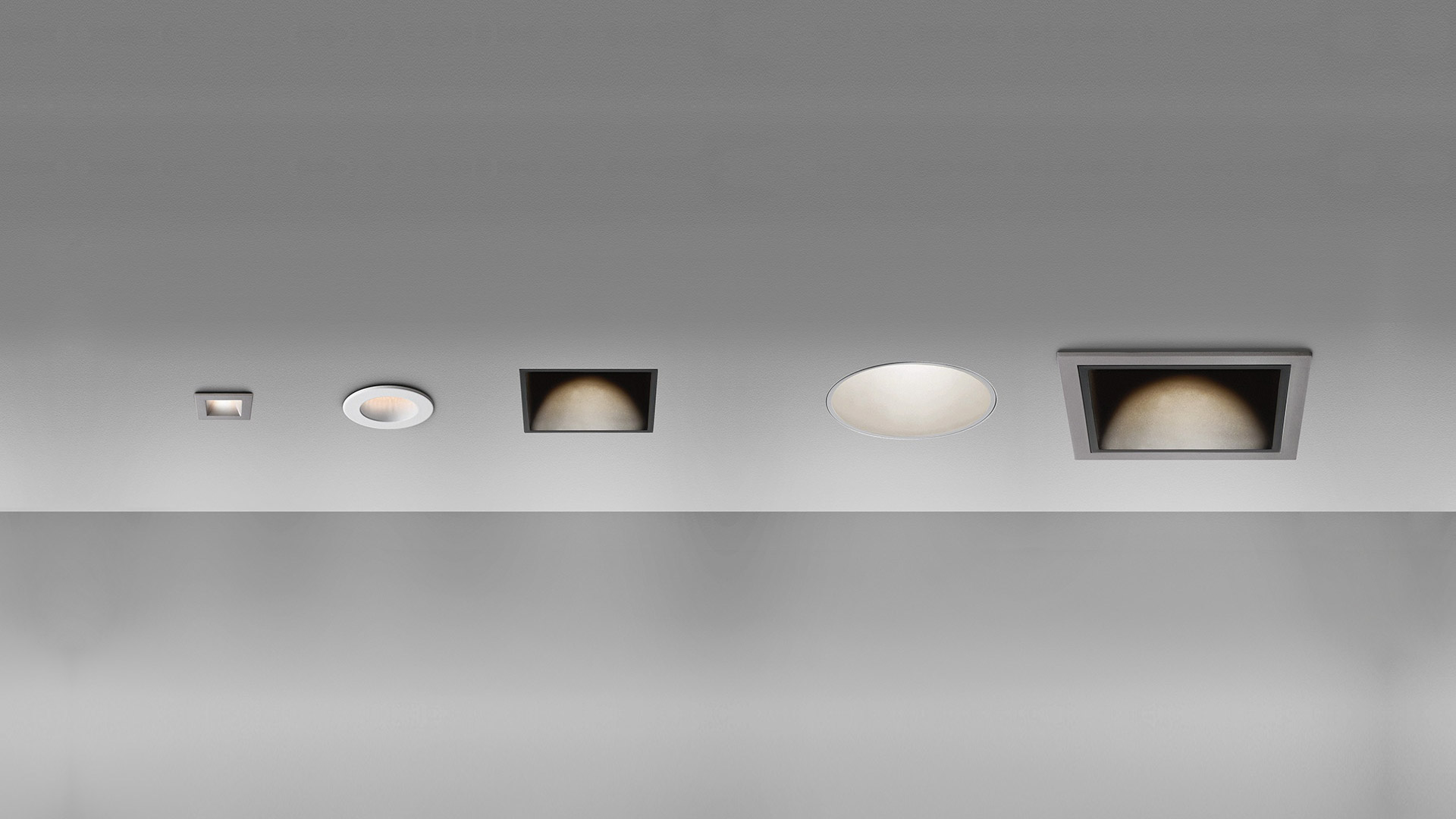 Five Artemide Everything recessed ceiling lights in a row: varying sizes, round and square trims in white and dark finishes