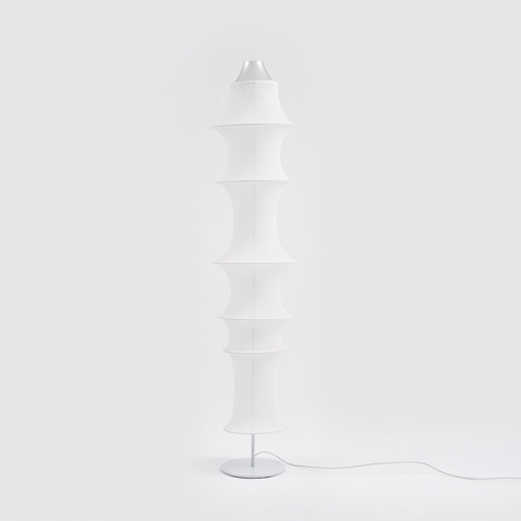 Artemide Falkland Terra floor lamp with stacked white fabric diffusers forming a tall cylindrical column on a slim white metal base
