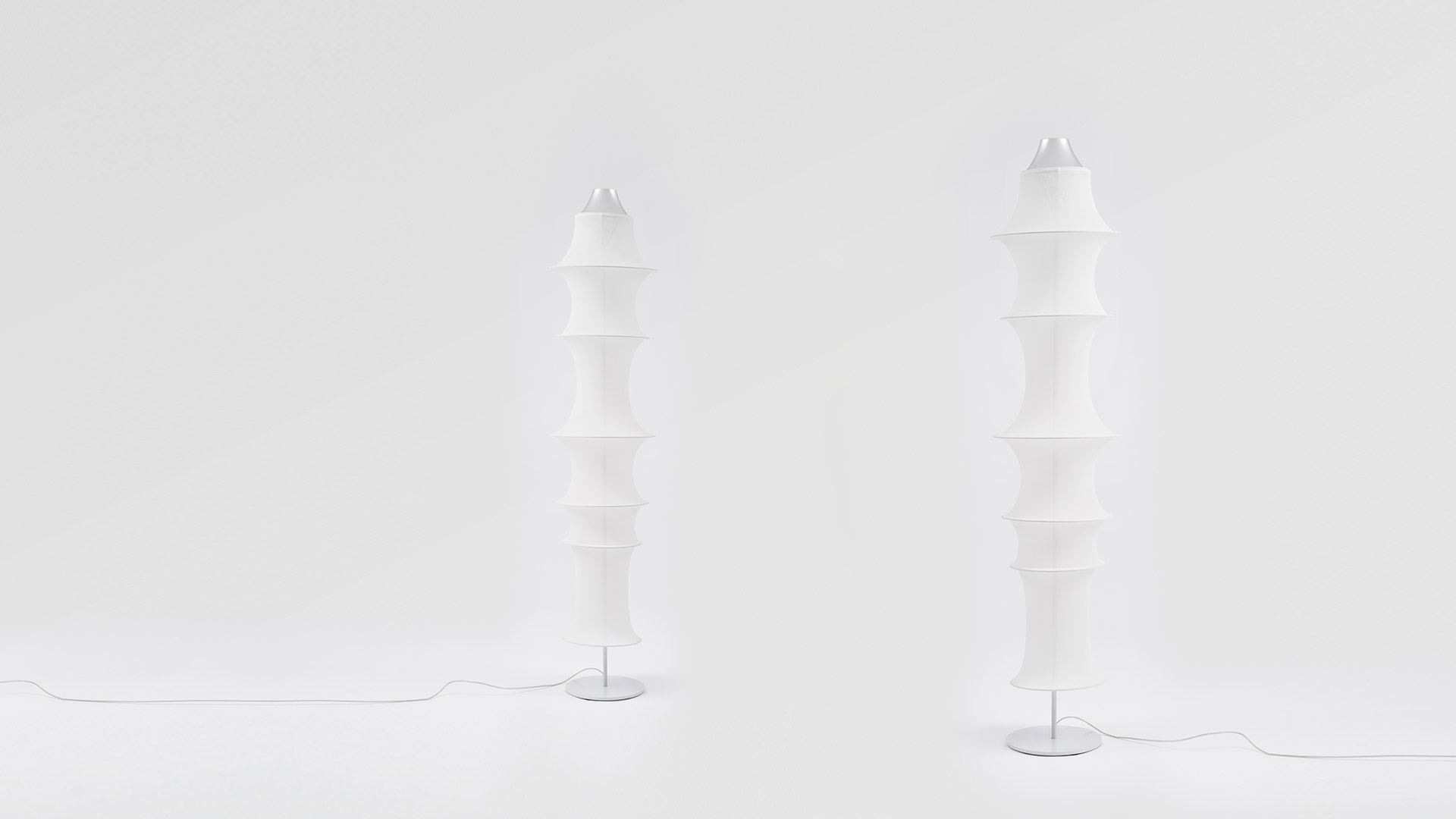 Two Artemide Falkland Terra floor lamps with stacked white fabric diffusers on slim metal bases, shown side by side