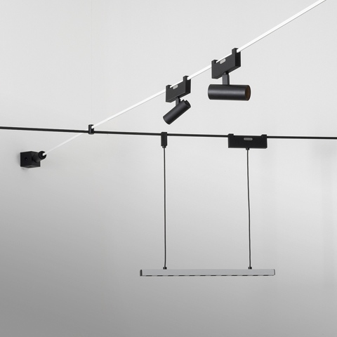 Artemide Funivia system: black cable track with two adjustable spotlights and a suspended rectangular LED panel hanging from wires