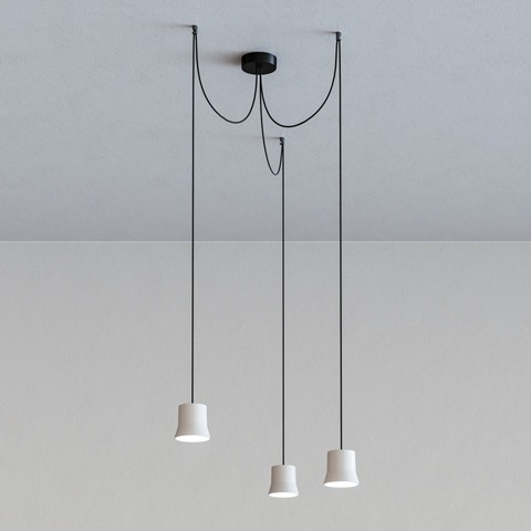Artemide Giò Light Cluster: three white conical pendant lamps hanging at varying heights from a single black ceiling canopy on black cords