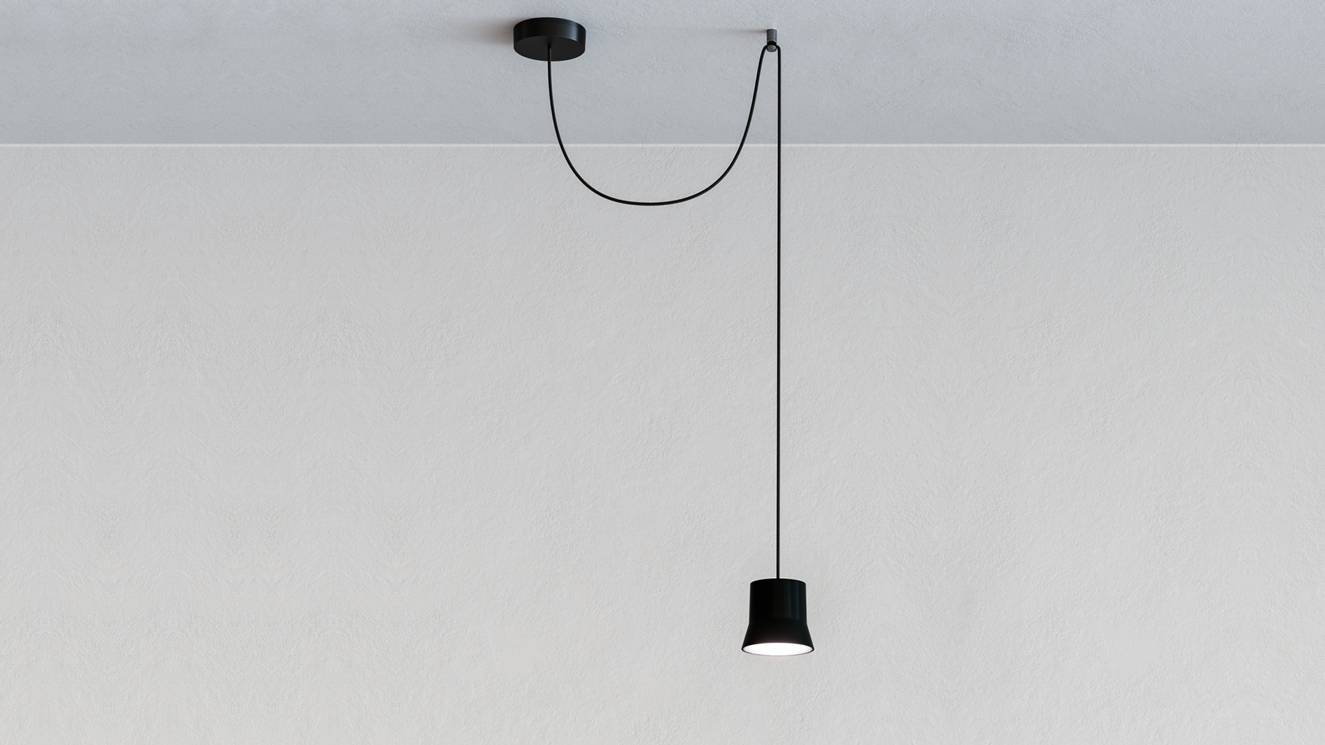 Artemide Giò Light Decentrata: black pendant lamp with cylindrical shade on asymmetric black cord from off-center ceiling canopy