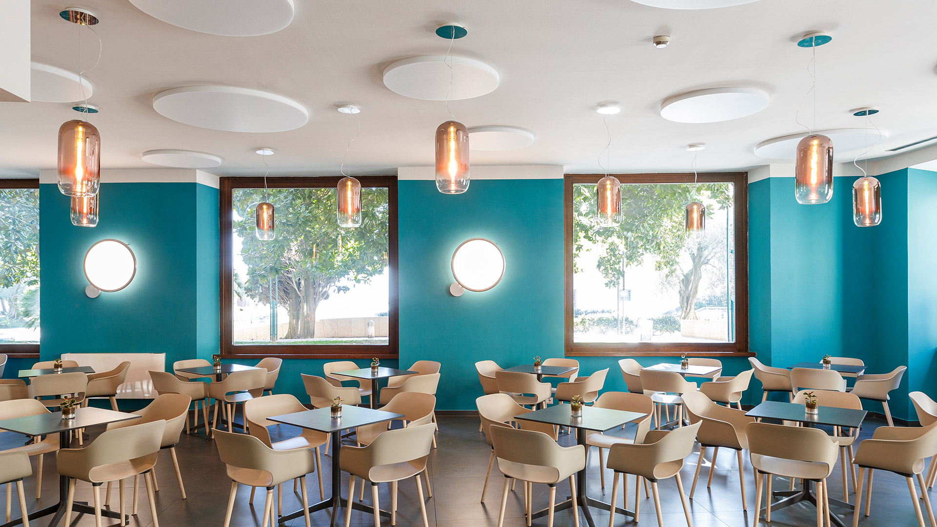Four Artemide Gople pendant lamps in a row: transparent, smoke grey, bronze, and white opal blown glass capsule shades