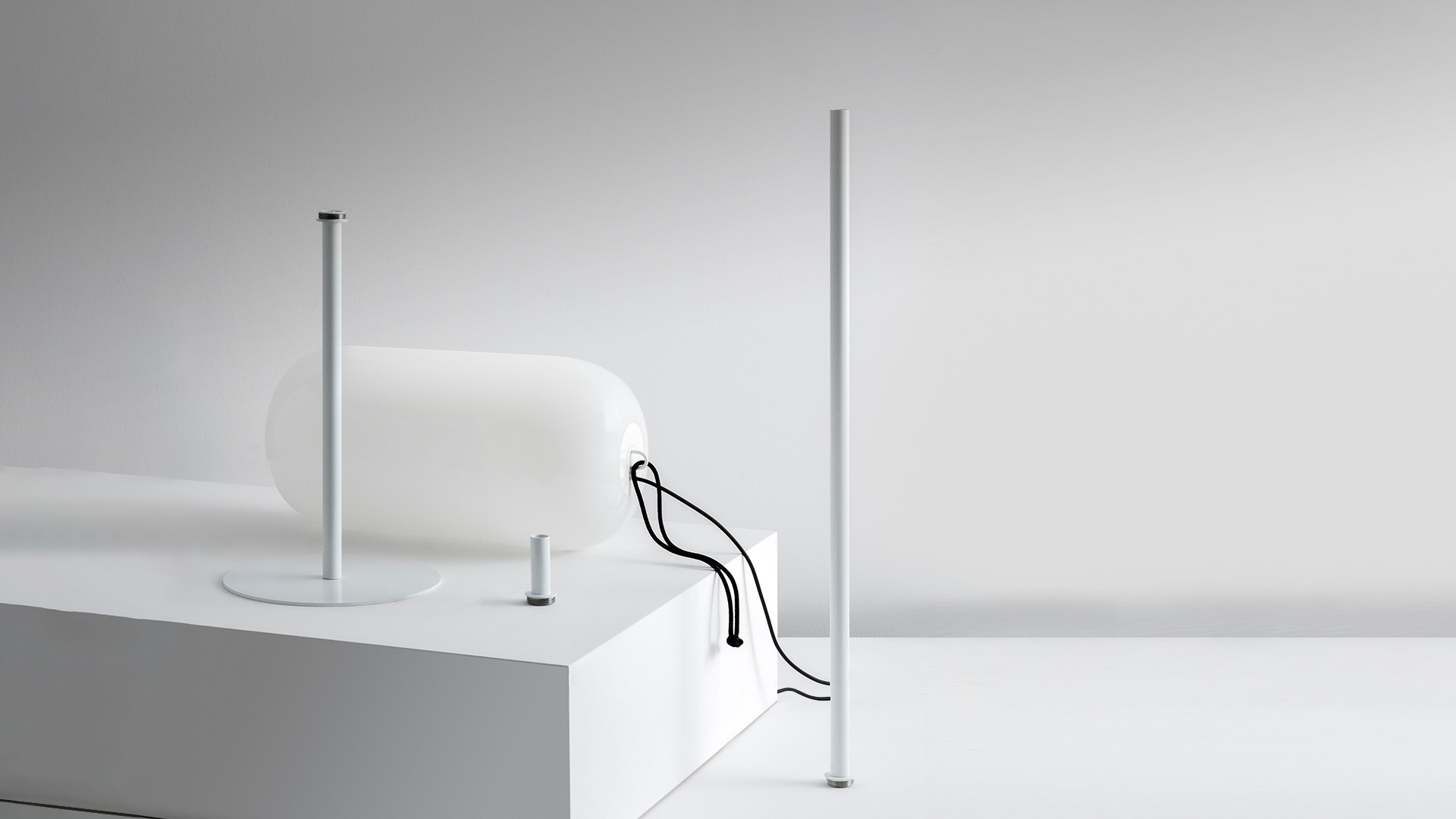 Artemide Gople Outdoor: white table lamp with organic glass shade on pedestal base and tall slim floor lamp pole, both in white