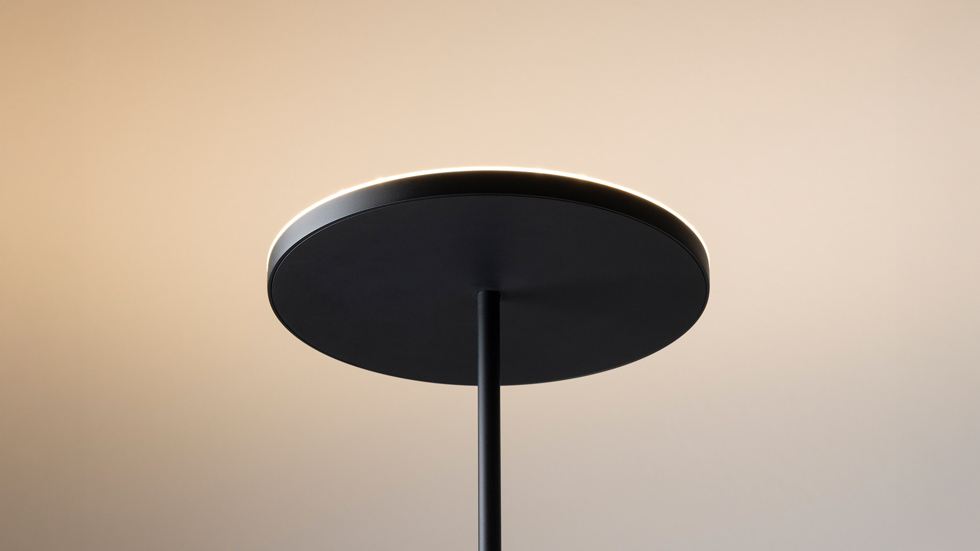 Artemide Helgoland pendant lamps in matte black suspended from ceiling, and Helgoland Archipelago floor versions on white pedestal