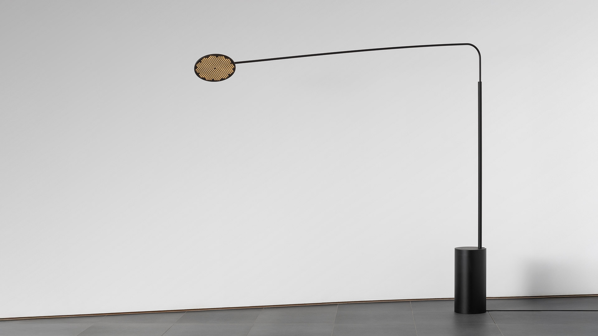 Two Artemide Helgoland Archipelago pendant lamps with dark circular discs featuring warm LED grid arrays, suspended against a deep blue sky