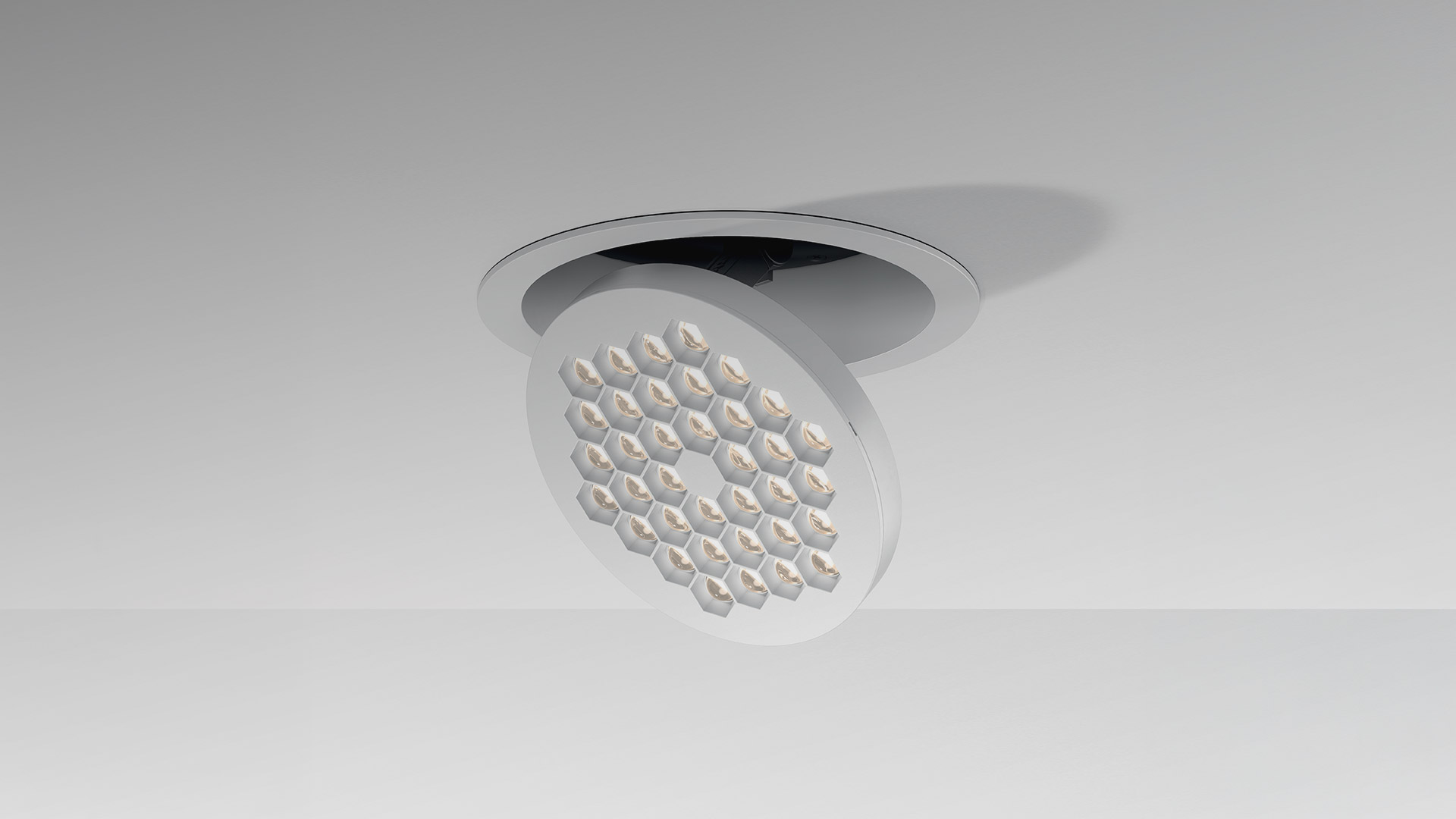 Two black recessed LED spotlights: left tilted adjustable version showing multi-lens array, right flush-mounted fixed version