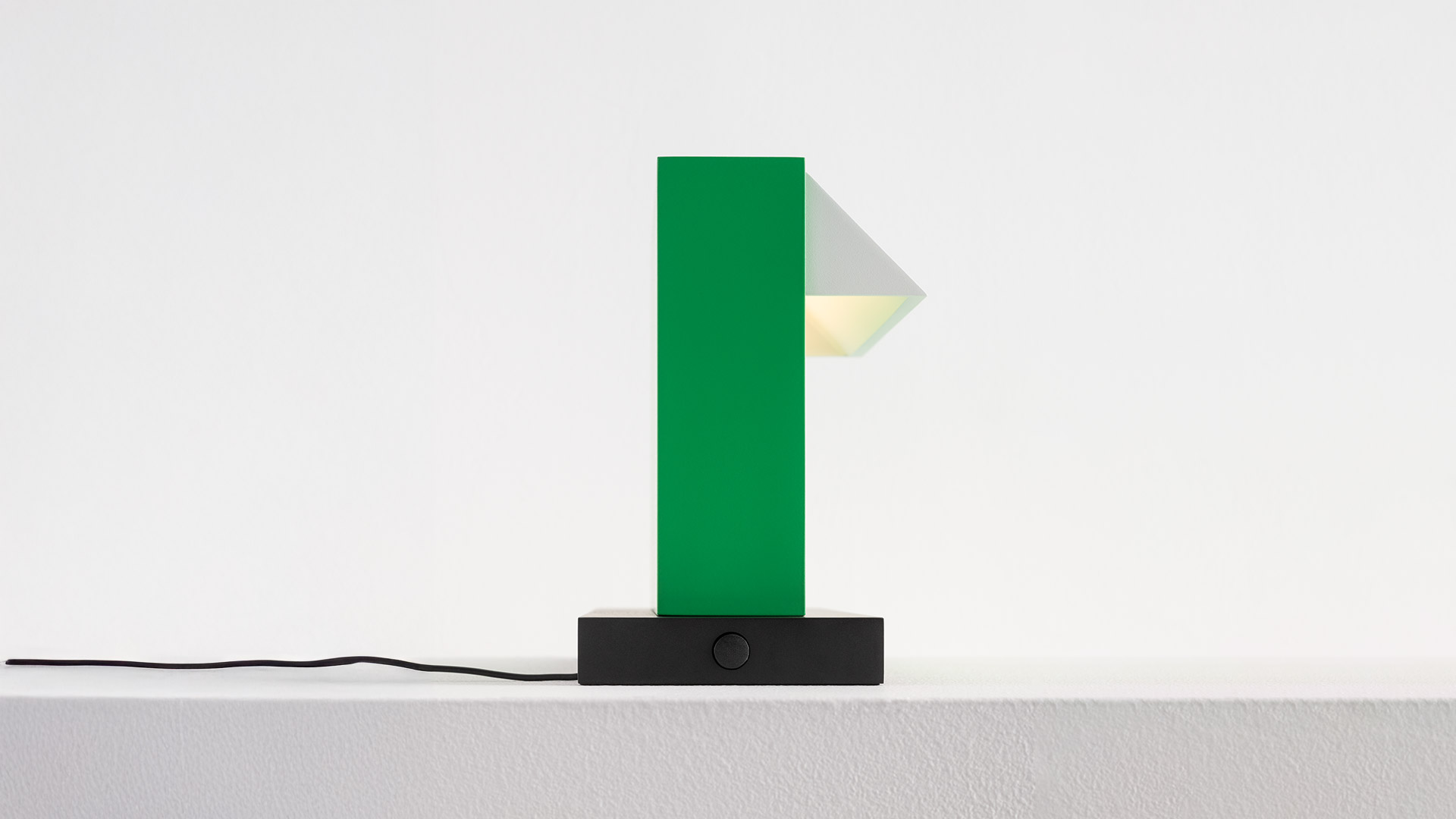 Artemide Hera table lamp: tall green rectangular body with triangular diffuser on black rectangular base with power cord