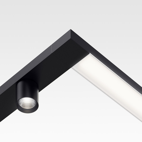 Artemide Hoy System: black angular track with integrated linear diffuser and adjustable cylindrical LED spotlight at corner junction