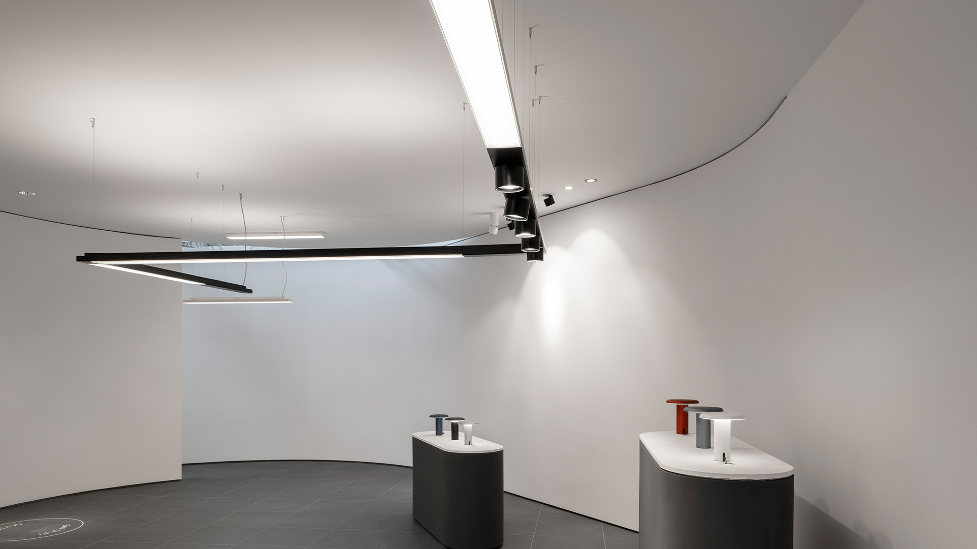 Artemide Hoy System: rectangular ceiling frame combining a linear LED strip and adjustable directional spotlights on a dark metal structure