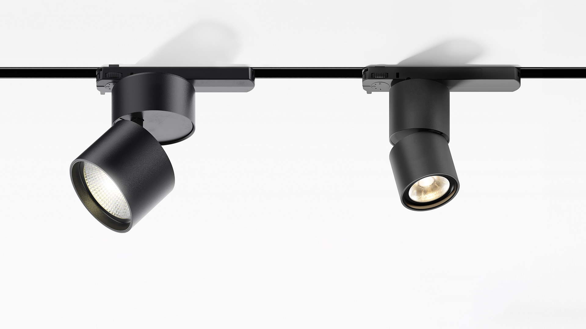 Three white cylindrical Artemide Hoy Spot track lights mounted on a black 3-phase rail, angled at different directions