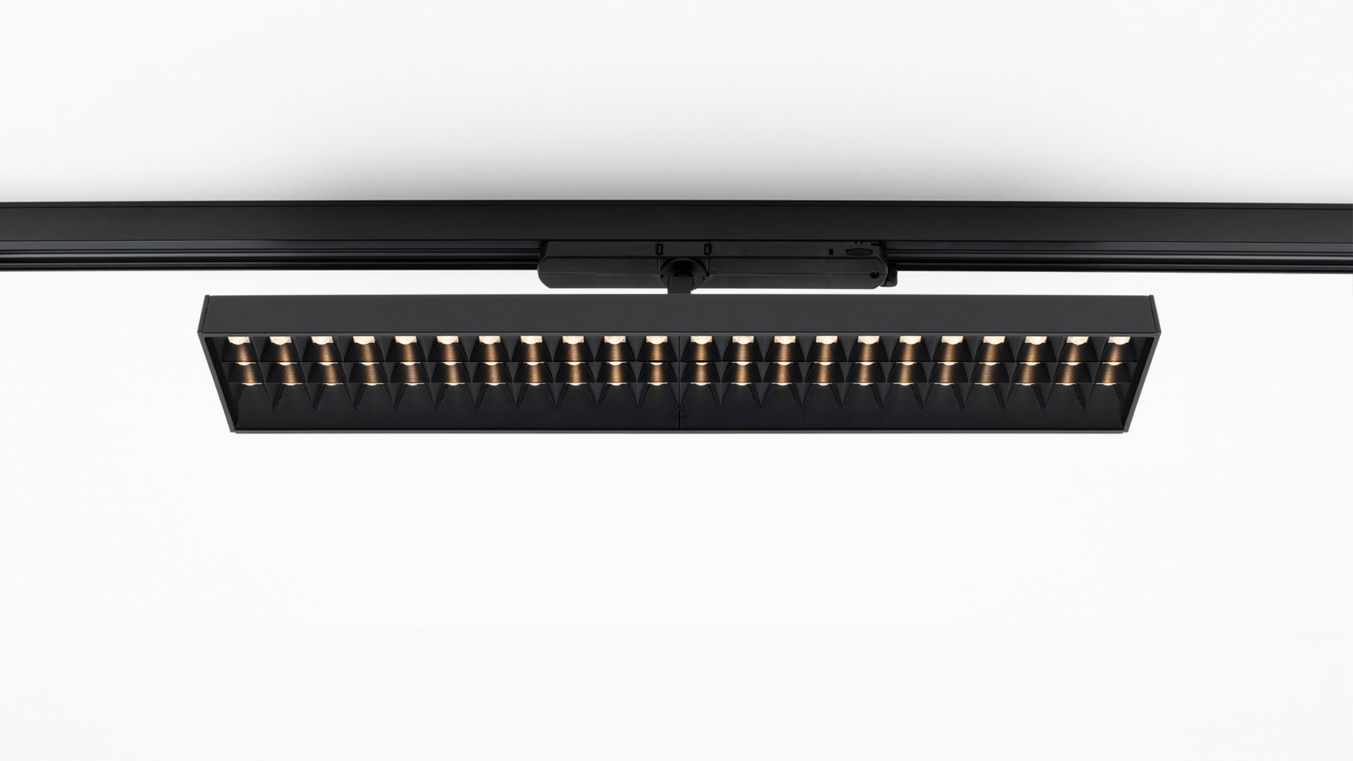 Artemide Hoy Refractive 3-Phase Track: black rectangular LED track light with a row of gold refractive lenses mounted on a black rail