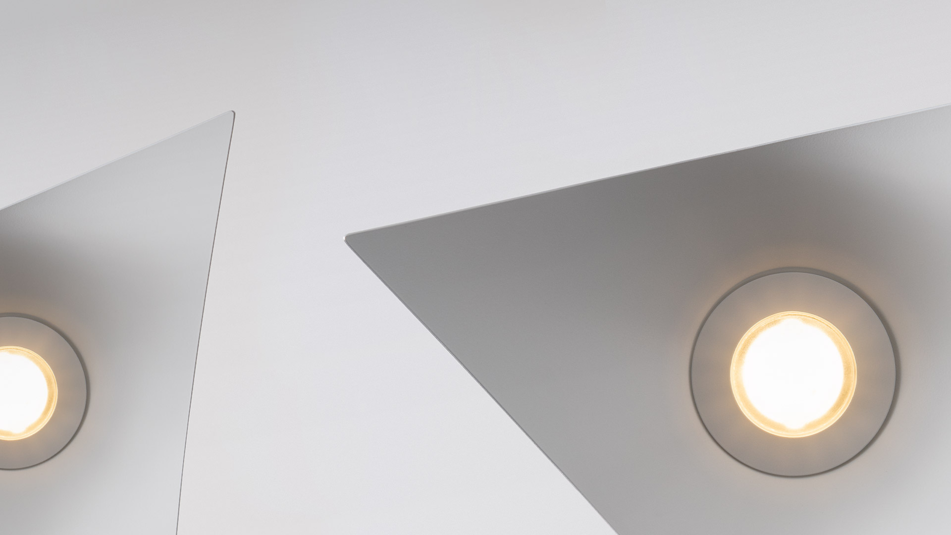 Two Artemide Iperbole pendant lamps with white wing-shaped shades suspended from thin cables against a white background
