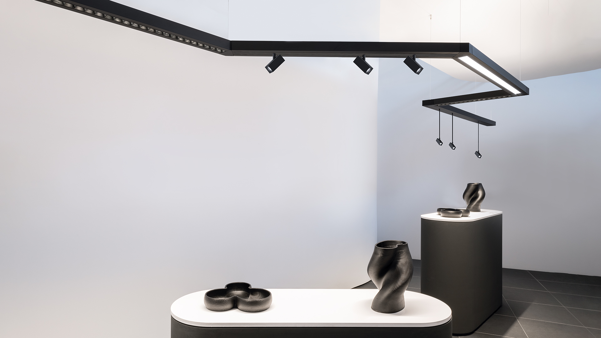 Artemide Katà Métron: angular pendant light system with red and yellow linear diffusers on dark rail, with adjustable spotlight