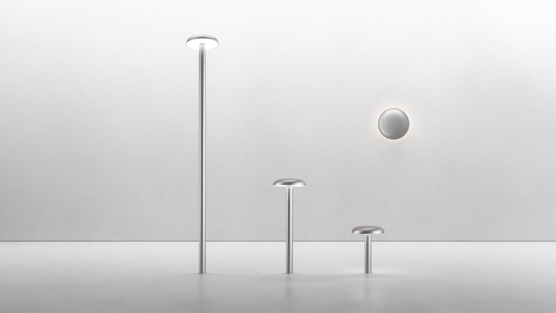 Artemide Knop outdoor bollard light with round flat diffuser on slim stem, placed on green grass lawn