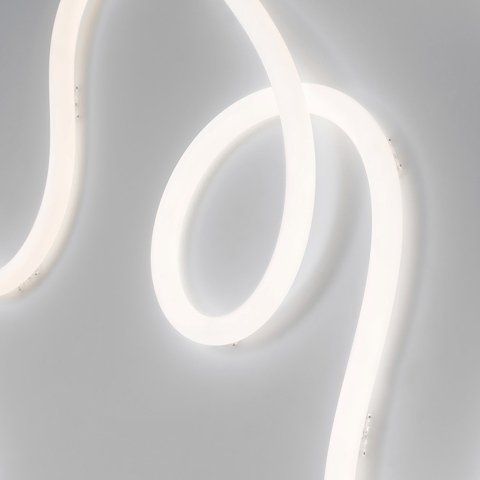 Artemide La Linea flexible LED light strip gracefully curved in sinuous loops, emitting soft diffused white light against a grey wall