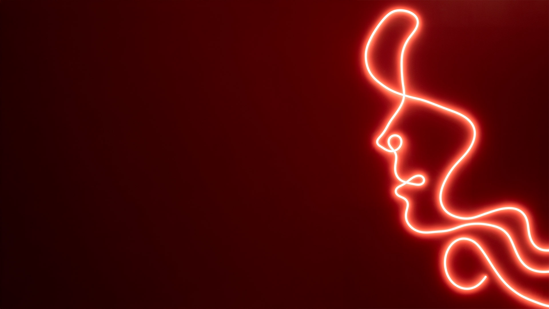 Artemide La Linea 25: glowing red neon-style flexible light tube forming abstract organic curves on a deep red background