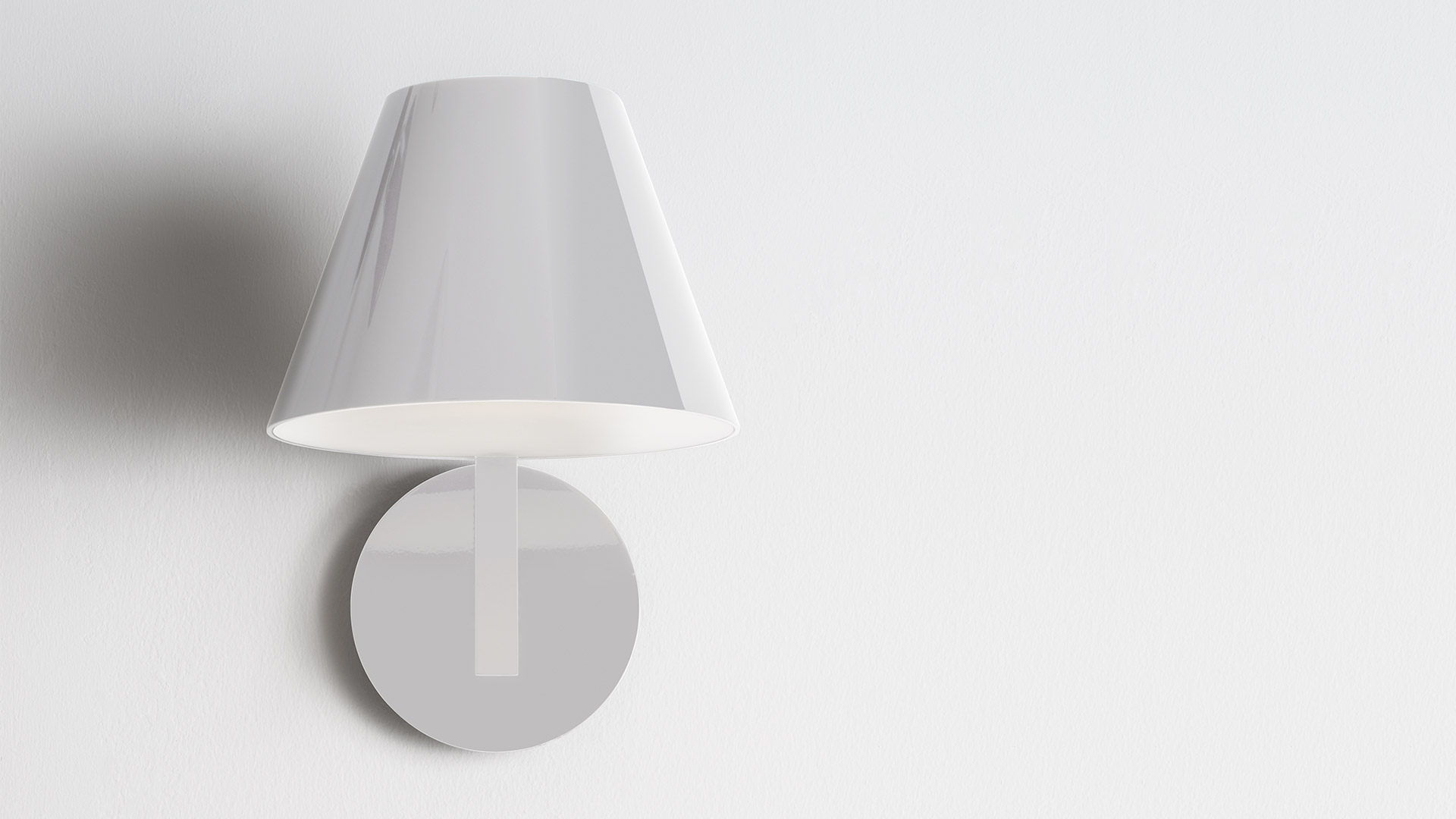 Artemide La Petite Wall sconce: glossy white conical shade mounted on a circular white wall plate, minimalist design