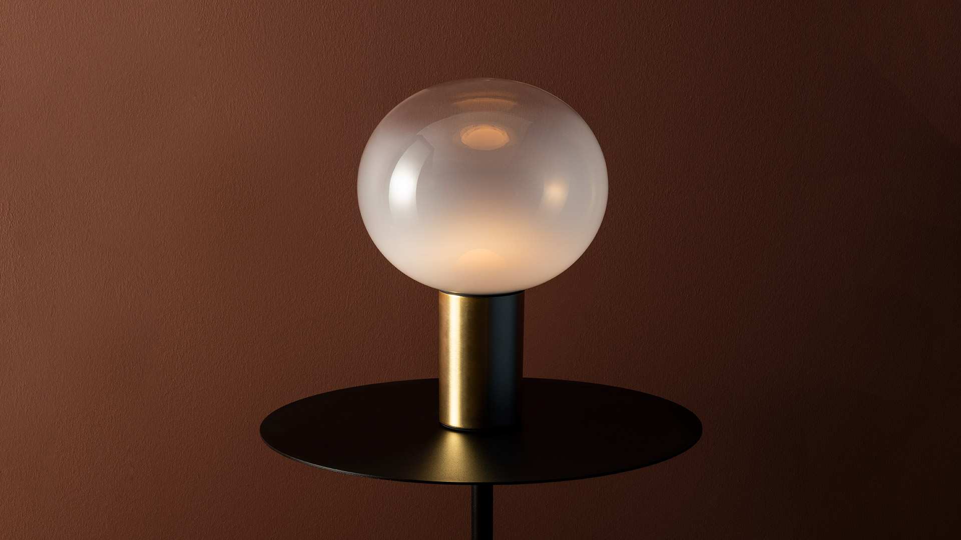 Three Artemide Laguna Tavolo table lamps in small, medium, and large sizes with opal glass globes on bronze cylindrical bases