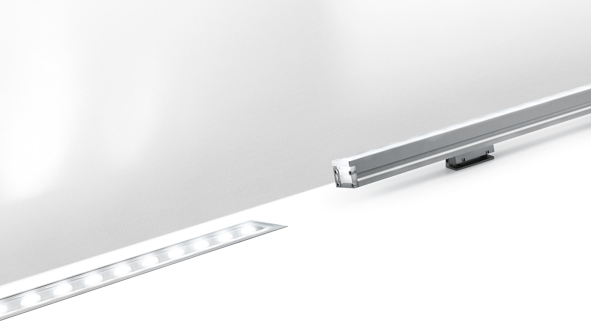 Artemide LineaLed Wallwasher: slim recessed linear LED fixture with aluminum profile emitting uniform light along a white wall surface