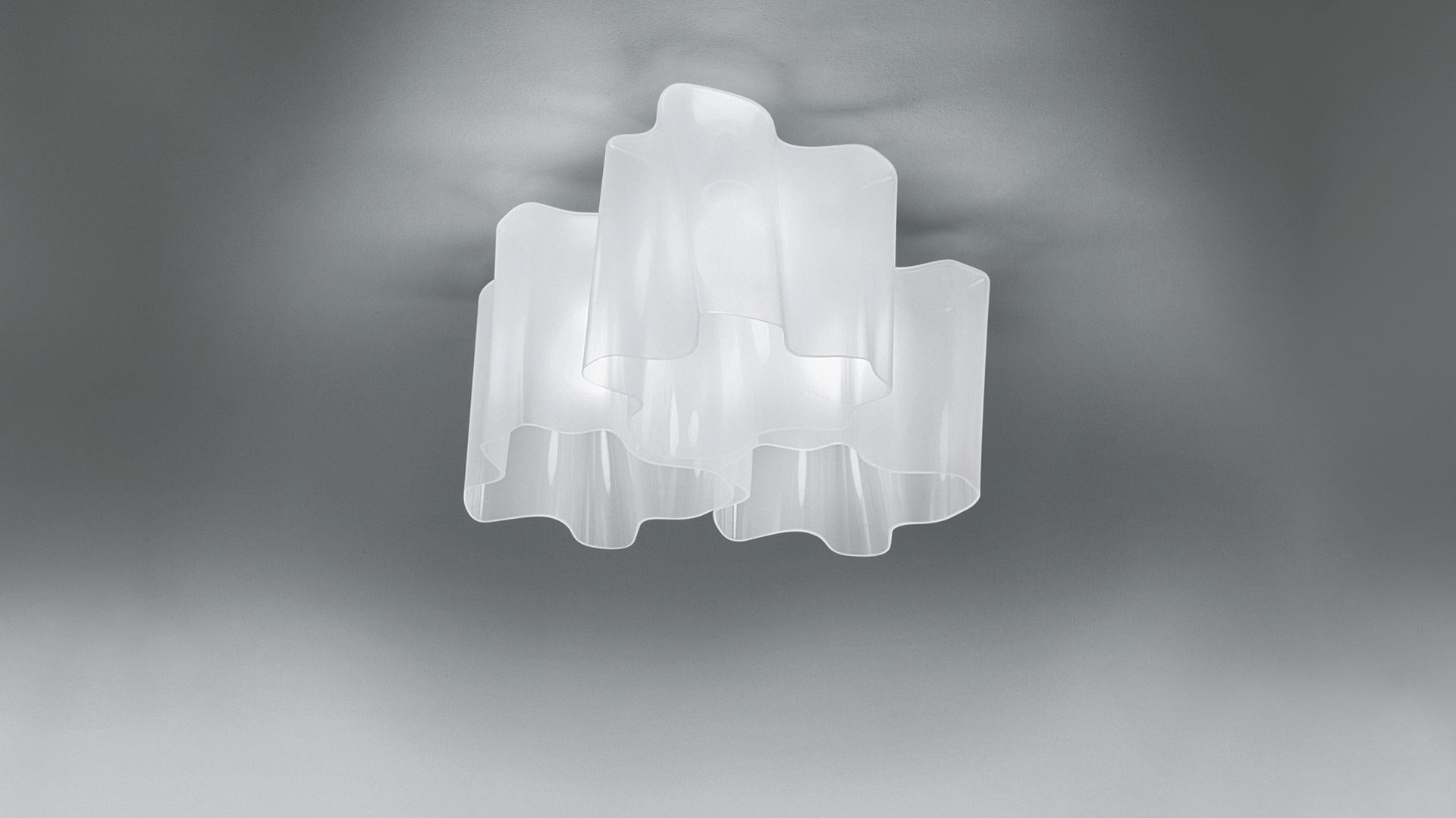 Artemide Logico Soffitto 3x120° ceiling lamp with three frosted white glass diffusers arranged in a flower-like pattern, emitting soft diffused light