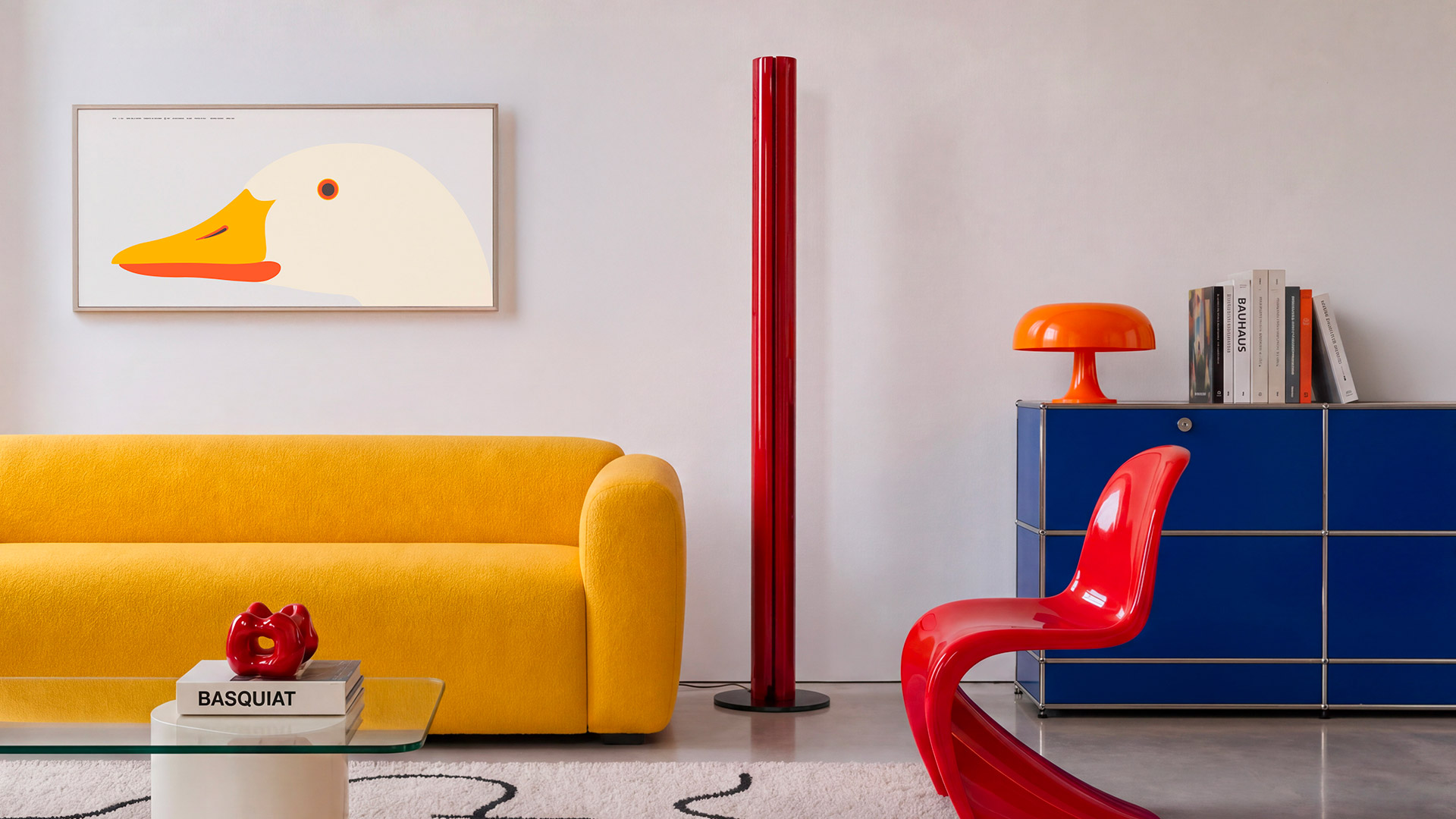 Two Artemide Megaron floor lamps: slim cylindrical columns on round bases, one polished aluminum, one matte black finish