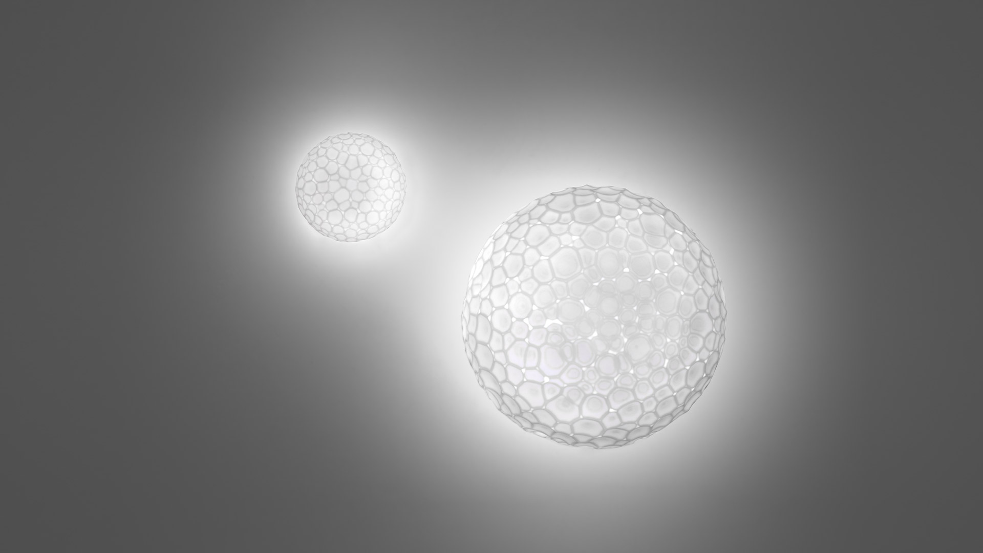 Two Artemide Meteorite wall/ceiling lamps with organic cellular spherical diffusers emitting soft white glow, small and large sizes