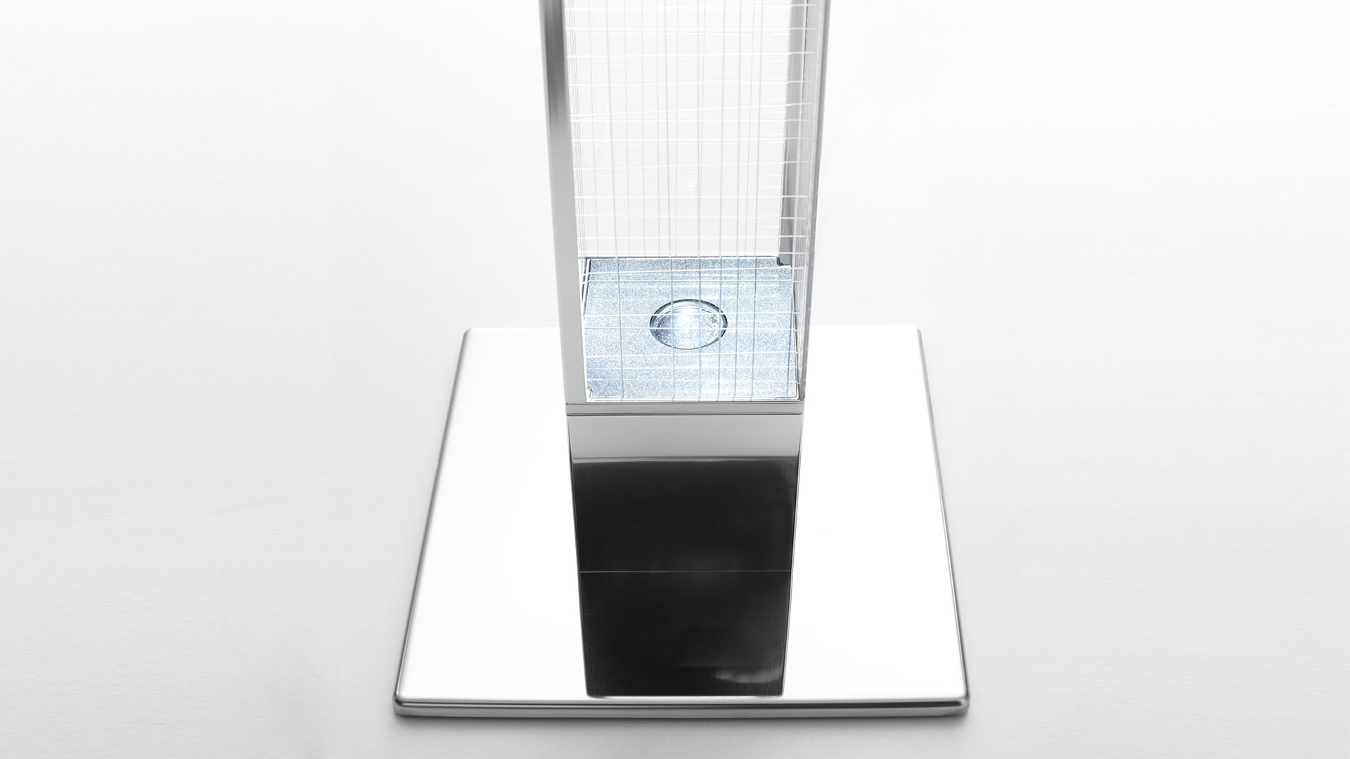 Mimesi floor lamp base detail: polished chrome square base with LED light source visible through transparent grid diffuser column