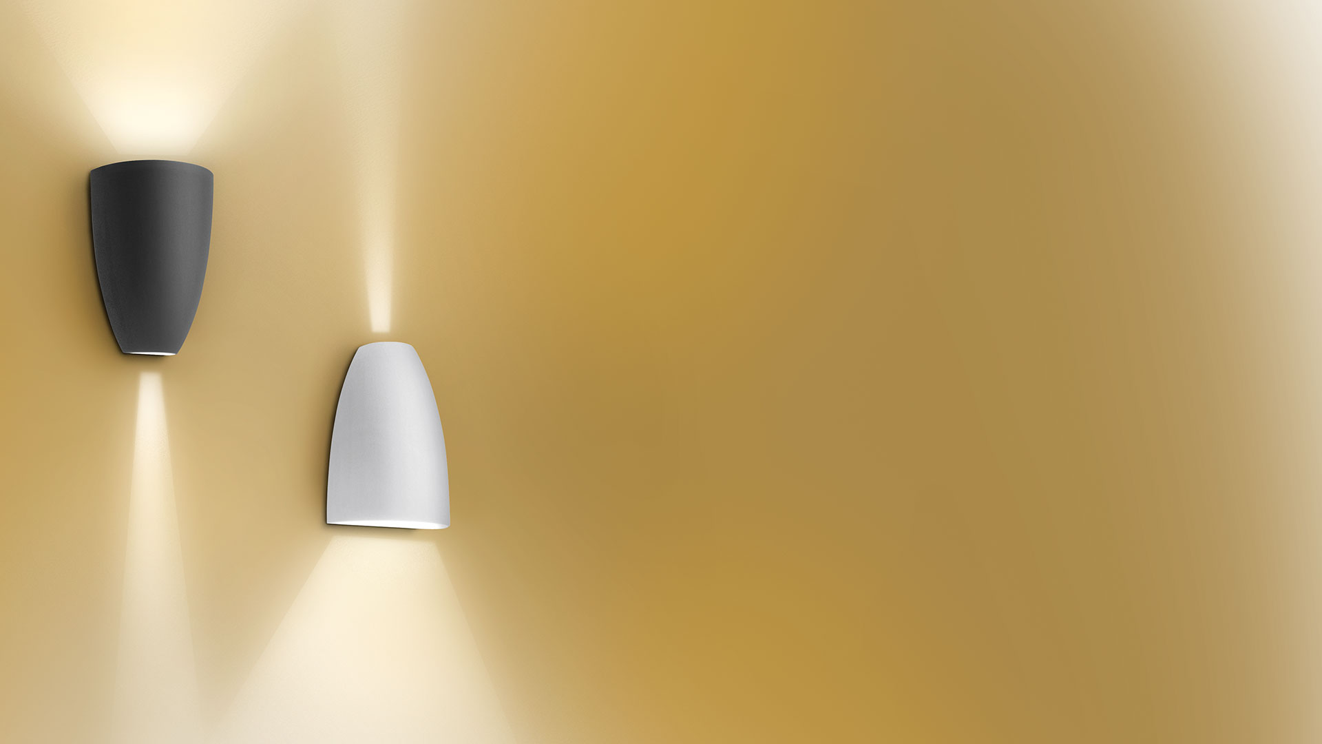 Two Artemide Molla wall lights on golden wall: dark grey and white versions, emitting warm upward and downward light beams