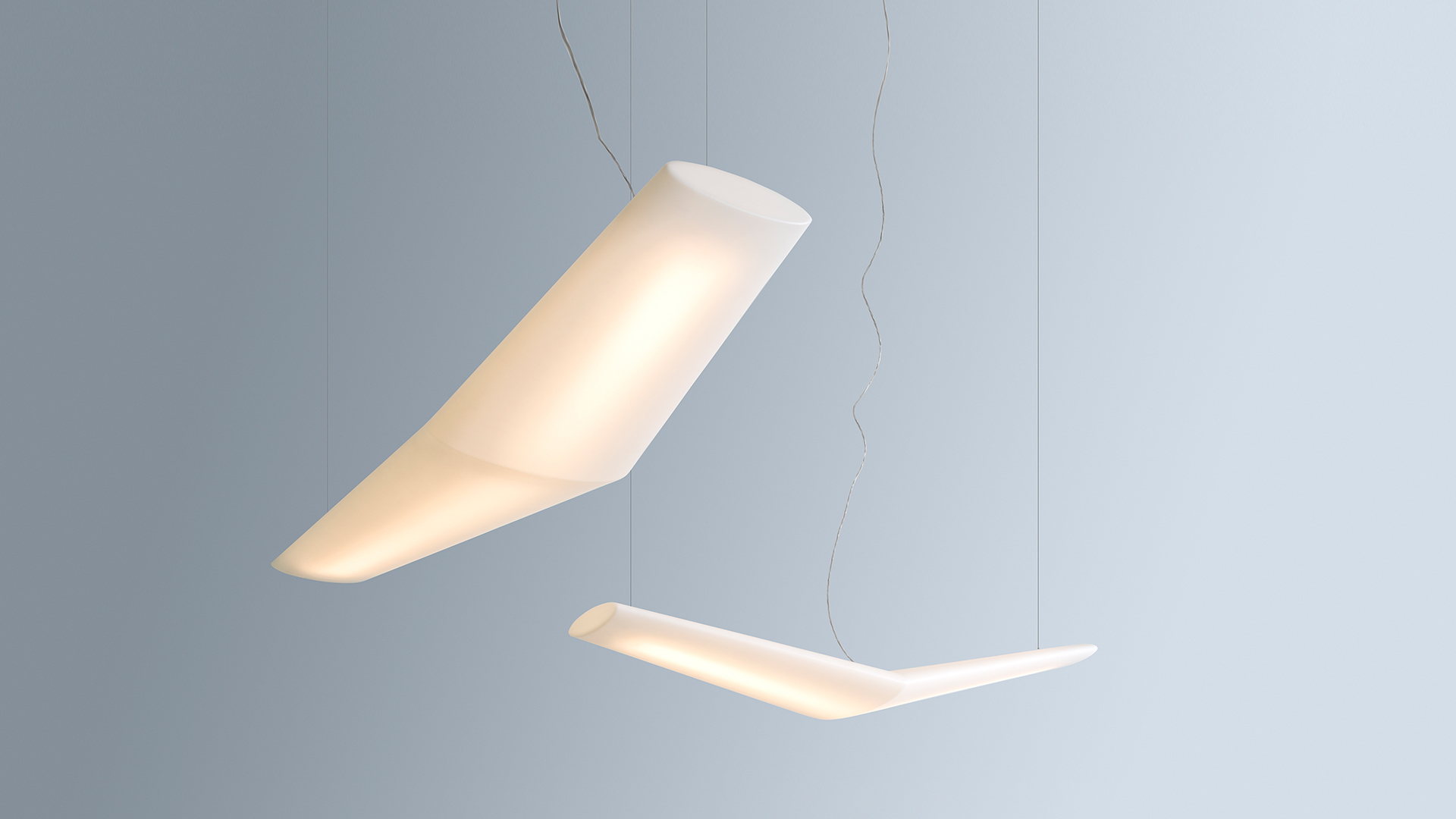 Two Artemide Mouette pendant lamps with angled white diffusers suspended at different heights on thin cables