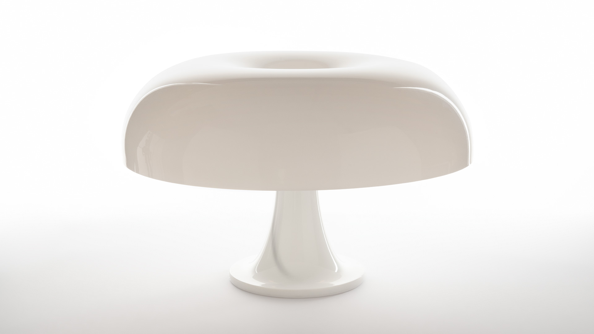 Artemide Nesso table lamp in burgundy red: iconic mushroom-shaped design shown alone and in a styled group with matching accessories