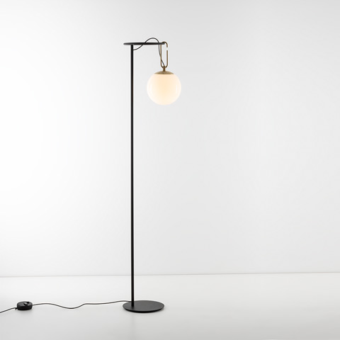 Artemide NH Terra floor lamp: slim black metal stem with round base, brass hook suspending an opal white glass globe shade