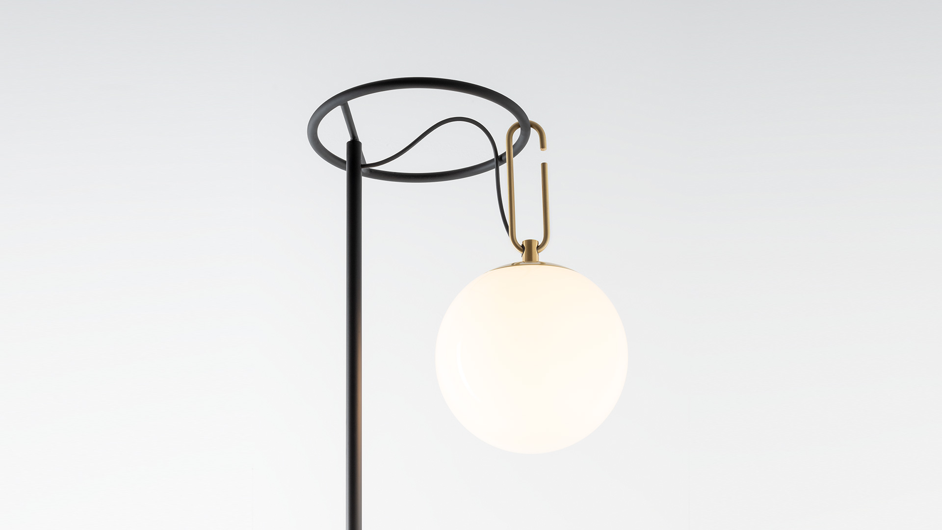 Artemide nh Terra floor lamp: black circular ring on vertical pole suspending a frosted glass globe via brass hook