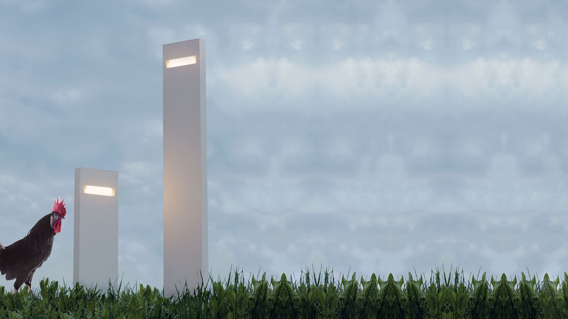 Modern building entrance at dusk with Artemide Nuda bollard lights lining a gravel path across a manicured lawn
