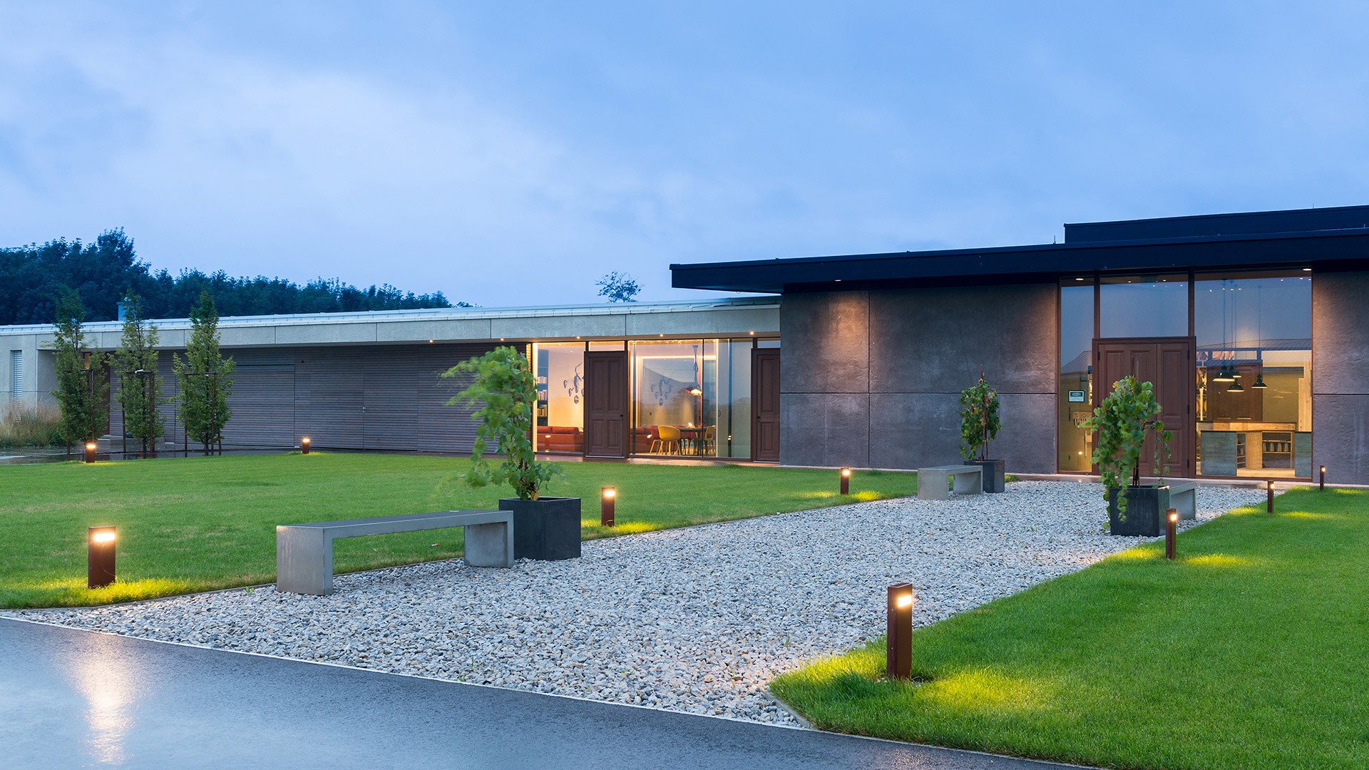 Artemide Nuda outdoor lights: two wall-mounted versions in grey and red, two bollard versions in dark grey and white with horizontal LED slot