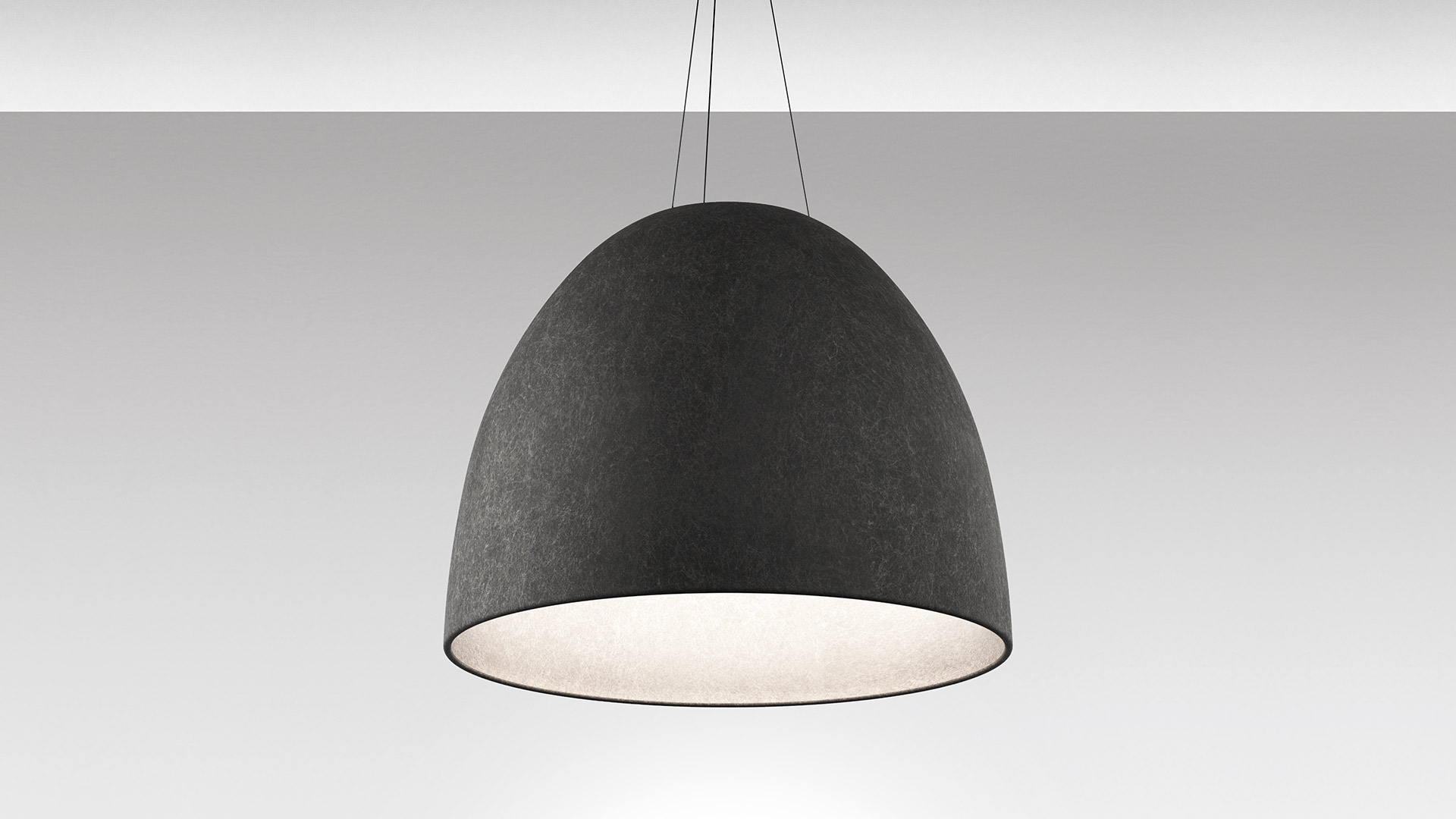 Modern office workspace with Artemide Nur Acoustic circular pendant lamp overhead, desk lamp, plants, exposed brick walls, and ergonomic workstations