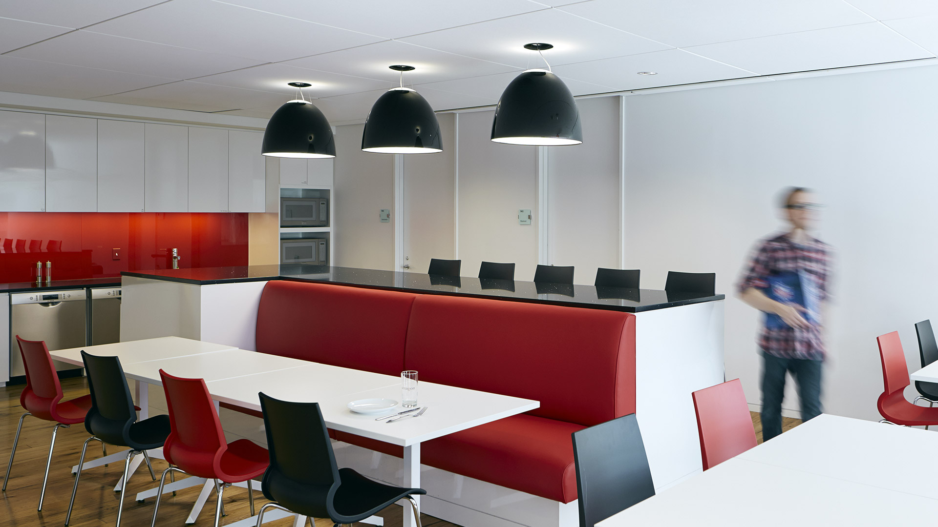 Artemide Nur Gloss pendant lamp with glossy white dome-shaped shade, suspended by a cable against a dark background
