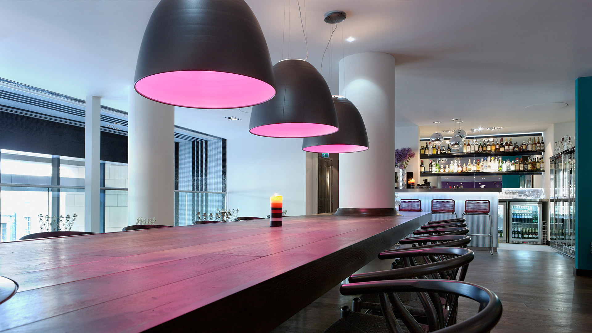 Artemide Nur ceiling lamp: matte black conical shade with warm golden interior diffusing soft ambient light