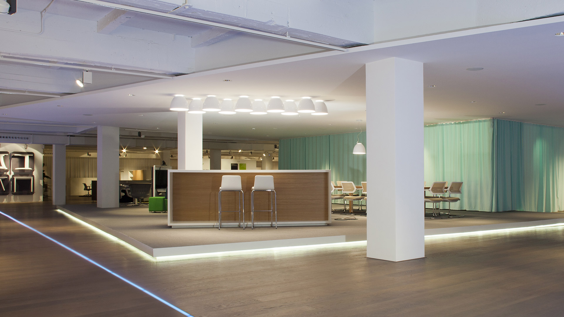 Two Artemide Nur pendant lamps: left aluminum silver dome shade, right dark grey dome shade, both suspended on thin cables