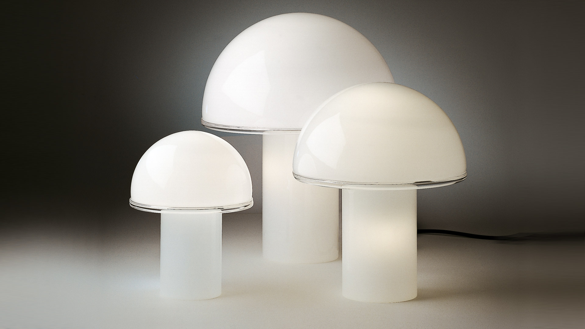 Three Artemide Onfale table lamps in white opal glass, mushroom-shaped, displayed in small, medium, and large sizes